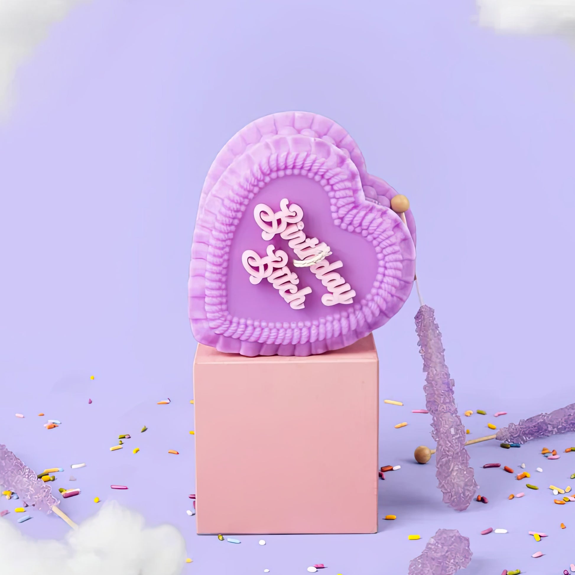 Heart-shaped pink object with 'Birthday bitch' text on a purple background with confetti.